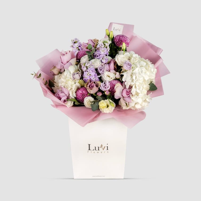 باقة سحر الاحتفال معروضة بشكل احتفالي في حقيبة هدايا احتفالية من لوفي فلاورز