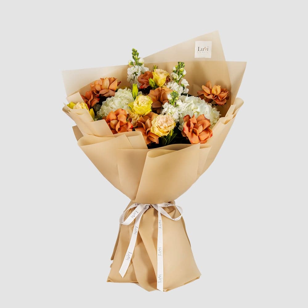 باقة زهور بدون سبب تضم ورود الكابتشينو، زهور الهيدرنجيا البيضاء، الماثيولا البيضاء، والليسيانثس الخوخي