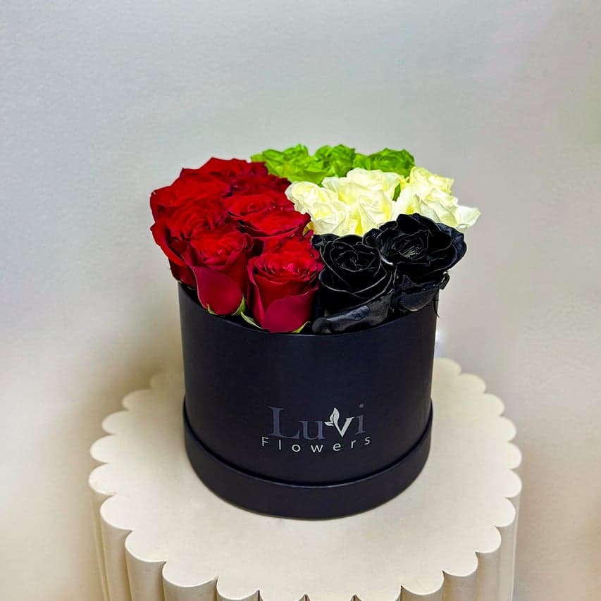 Medium Pride & Prosperity box arrangement showcasing a patriotic mix of white, red, green-sprayed, and black-sprayed roses	