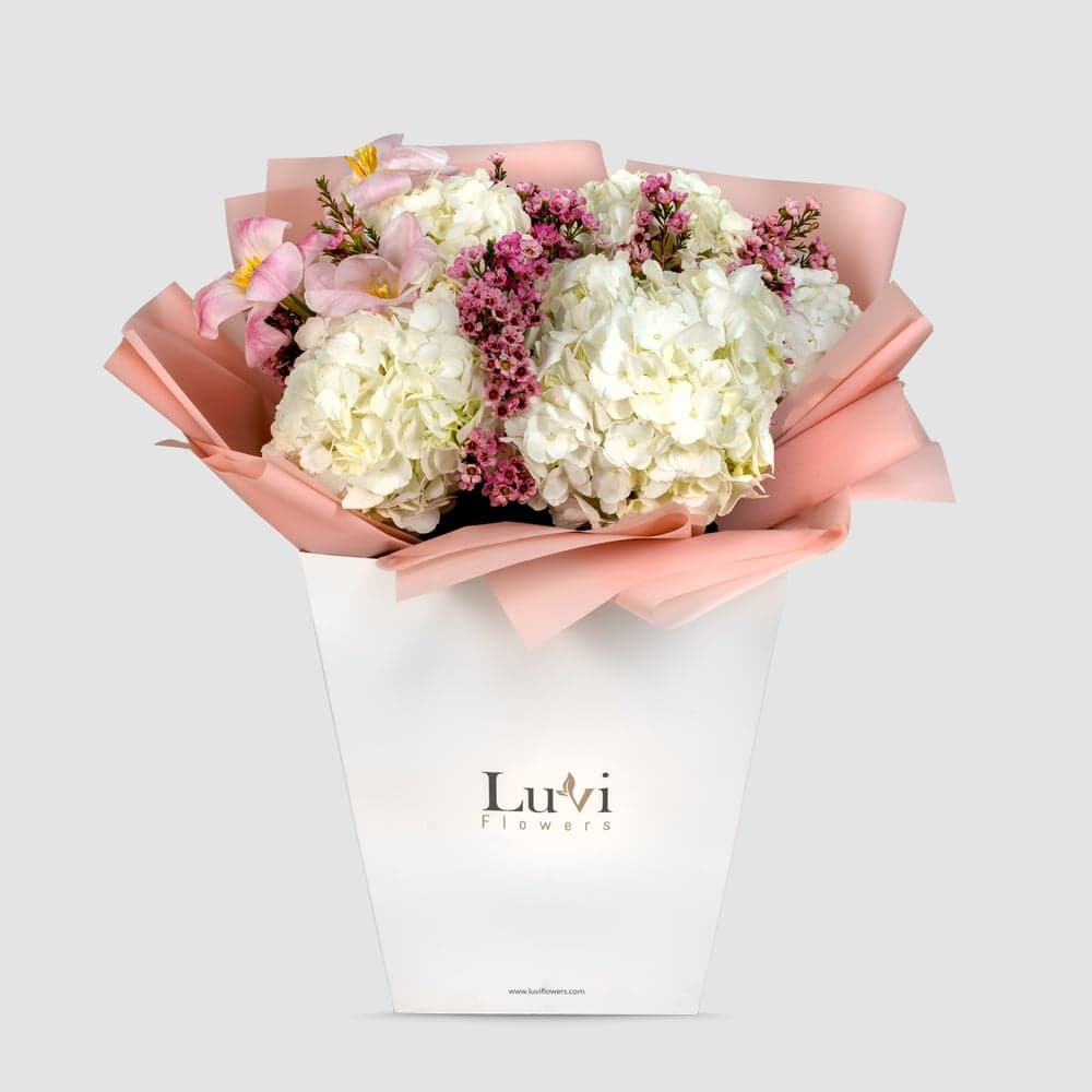  Gentle Hug – White hydrangeas, purple wax flowers, and pink tulips bouquet. thumbnail