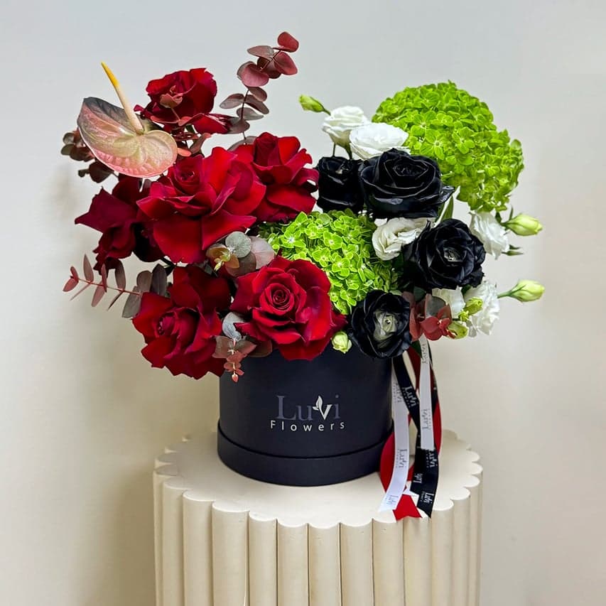 تنسيق صندوق زهور الوحدة المتوسط مع مزيج متناغم من الورود الحمراء، الهيدرنجيا الخضراء، الليسيانثس الأبيض، والأنثوريوم